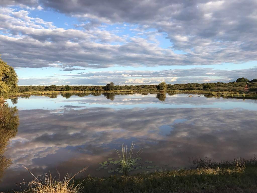 African landscape with lake reflecting the sky